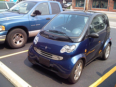 Front and side view of a blue Smart Fortwo in a parking space next to an ordinary pick-up truck by fleur-design on Flickr